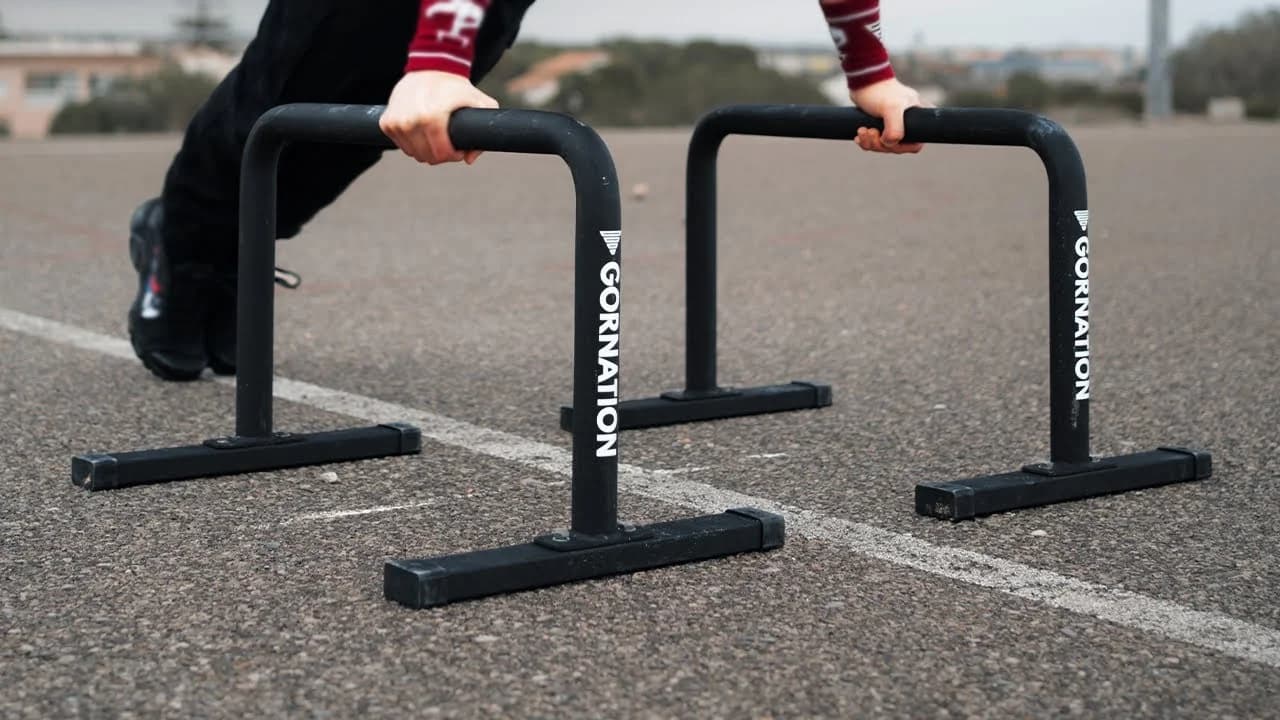Daniel Hristov performing a handstand push-up on GORNATION metal parallettes during a home calisthenics session