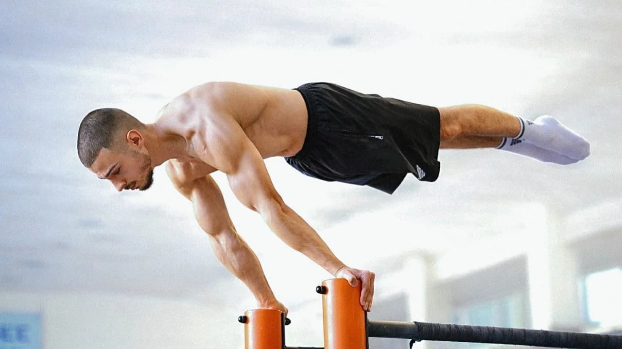 Daniel Hristov holding a full planche with straight arms in the legendary gym during his planche workout