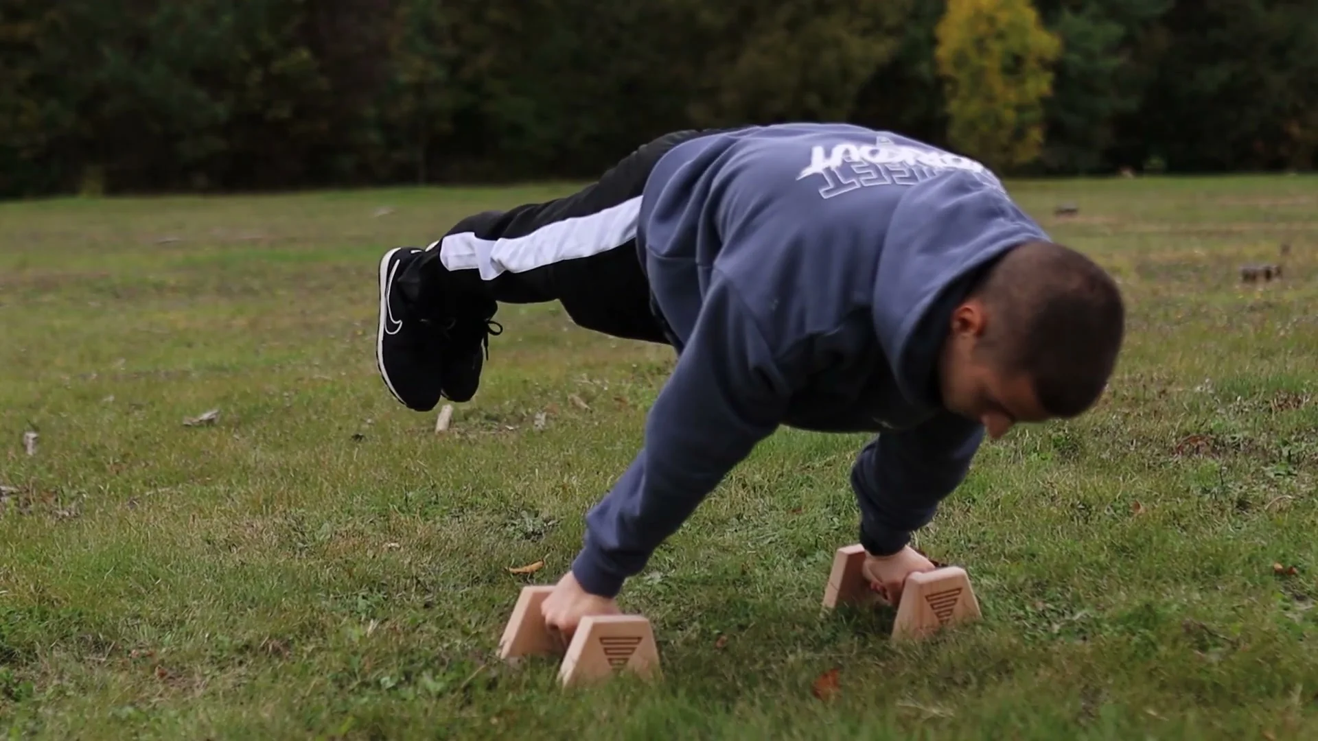 Daniel Hristov testing the assembled wooden GorNation parallettes with a push-up on grass