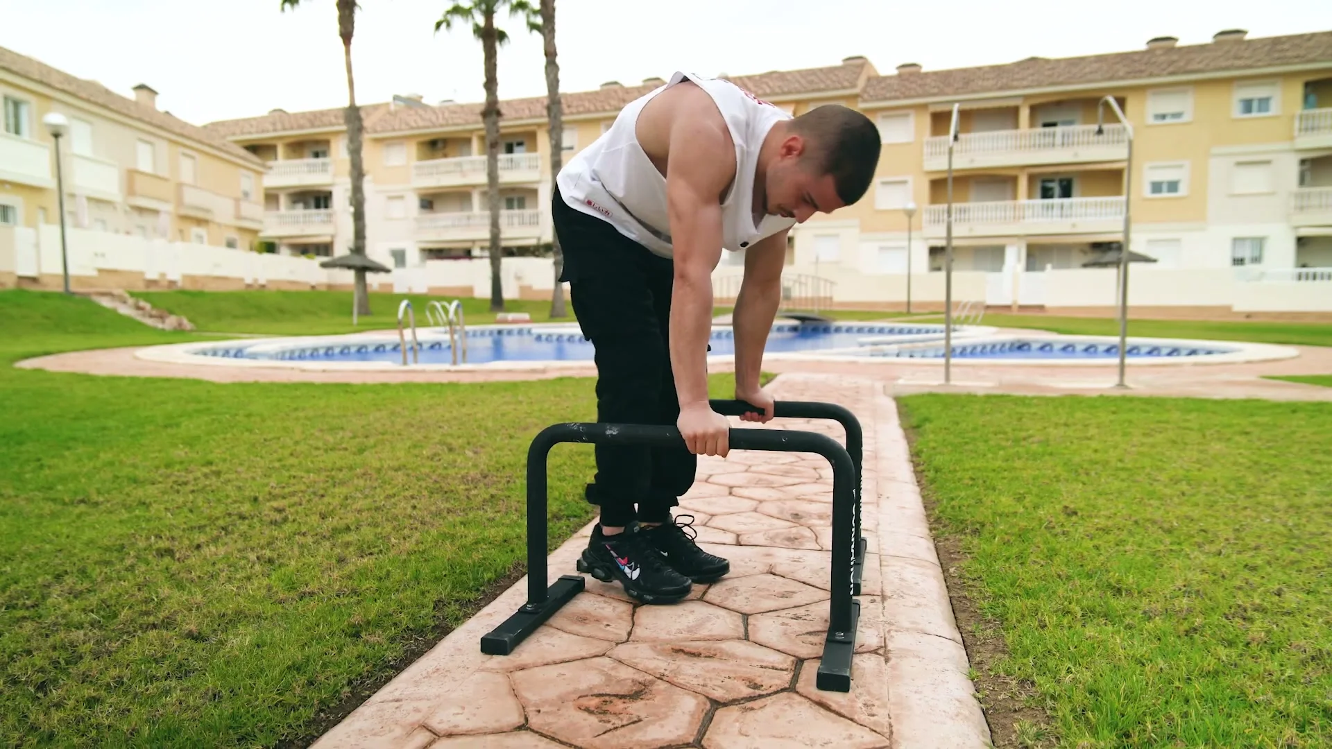 Close-up of Daniel Hristov gripping the thick matte steel bar of the GORNATION metal parallettes