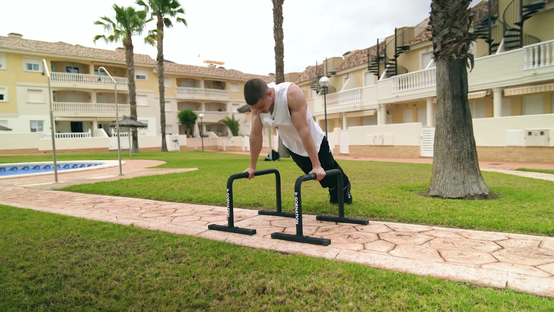 Daniel Hristov performing a push-up on the GORNATION metal parallettes on an outdoor path